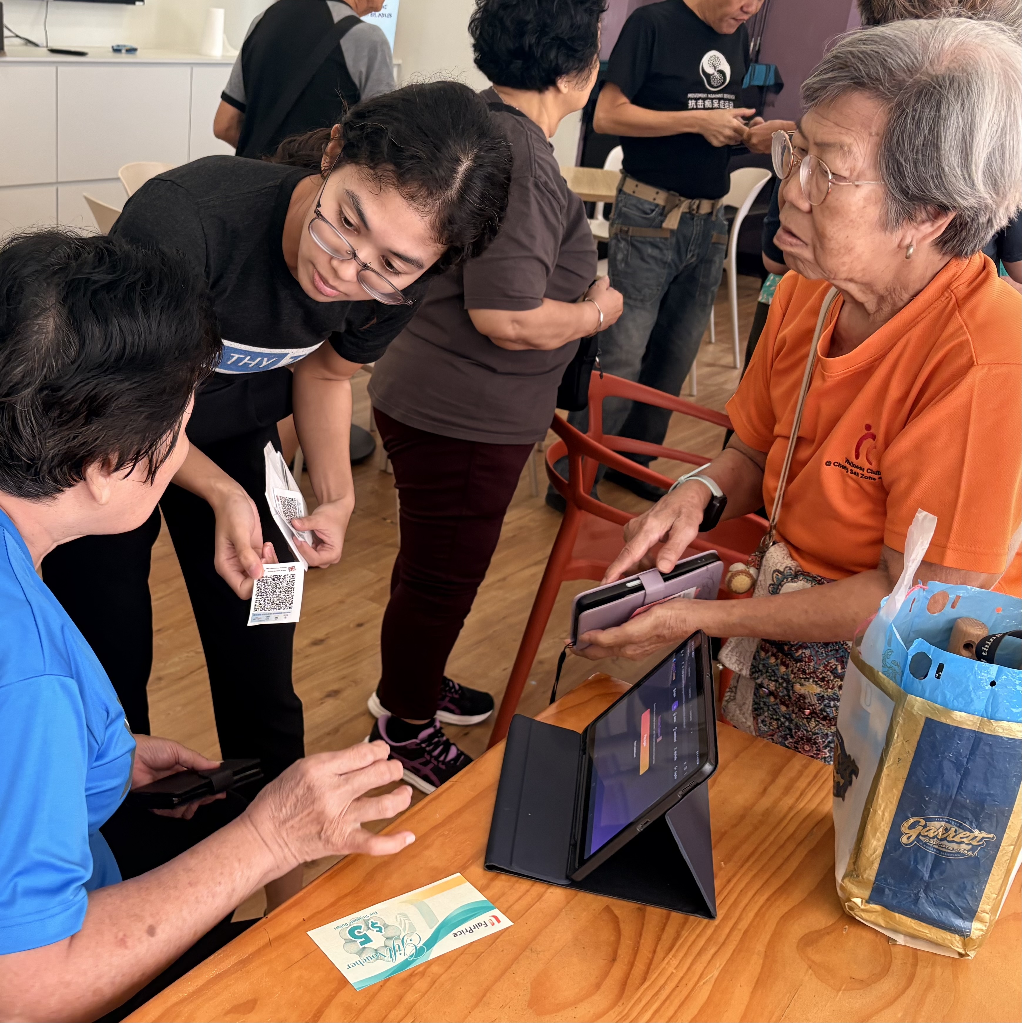 Seniors using their phones with a facilitator at an Active Ageing Centre
